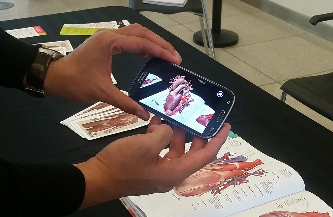 Markus Santoso uses a smartphone to turn a regular medical textbook into a 3D learning tool.