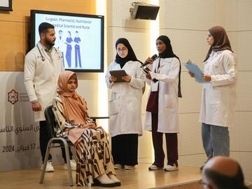 A group of five students present on stage