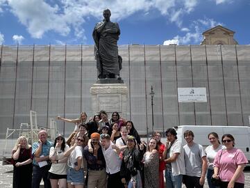 A group of people in front of a statue in Italy