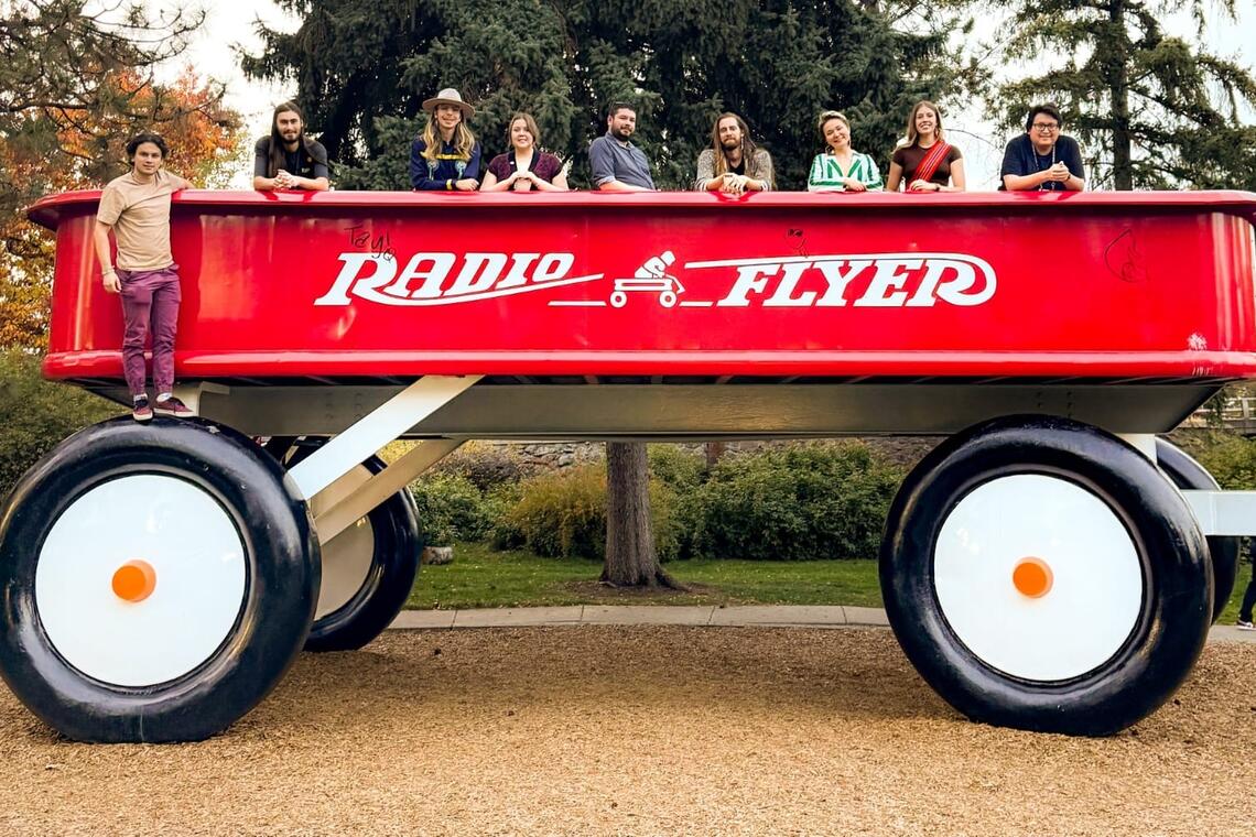 students posing on a giant red wagon