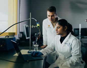 two CPE graduate students working in a lab together